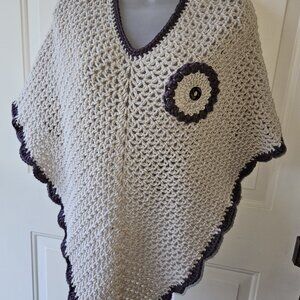 PONCHO IN BEIGE AND BROWN TRIM WITH MATCHING DECORATIVE FLOWER